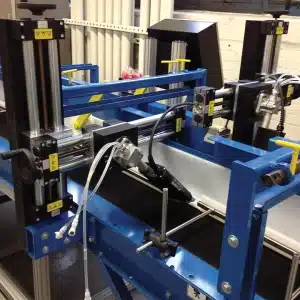 Maßgeschneiderte Plattform für die Industrieautomation mit mehreren Werkzeugköpfen, Positioniereinrichtungen und integrierten Steuerungen in einem Rahmen aus blauem Stahl.