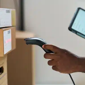 Ein Mann mit einem Scanner und einem Tablet, der 2D-Barcodes überprüft