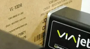Matthews Marking Systems Ein Drucker der VIAjet™ T-Serie, der hochauflösende Texte und Barcodes direkt auf einen Karton aufbringt.