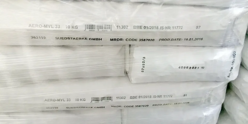 In Plastikfolie verpackte Industriesäcke, die mit Produktangaben, Barcodes, Chargennummern und Herstellungsdaten gekennzeichnet sind.