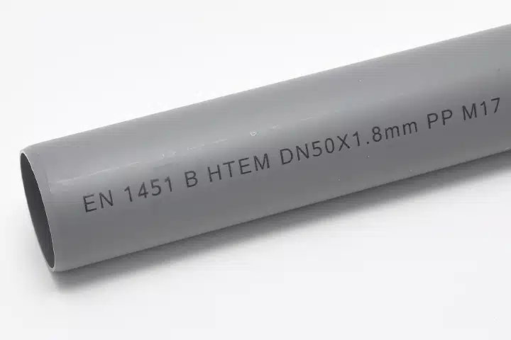 Tinte r, industriell gedruckter Identifikationscode auf einem grauen PVC-Rohr zur Rückverfolgbarkeit des Produkts.