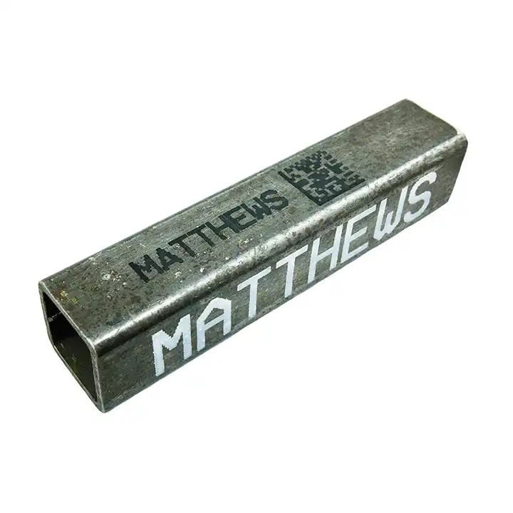 Metallbeschriftung mit schwarzer und weißer Tinte auf einem Vierkantrohr.