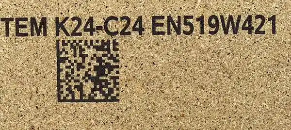 Auf Spanplatte aufgedruckter 2D-Code und alphanumerischer Text