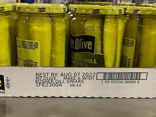 Markierungen und Barcode auf einer „Mount Olive Pickle“-Kiste mit Gurkengläsern, die den Aufdruck auf der Kundenkiste, die Kartonkennzeichnung und die Etikettierung der Kiste zeigen.
