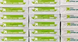 Stapel von verpacktem Druckerpapier im Letter-Format mit grünen und weißen Etiketten, die in Reihen angeordnet sind.