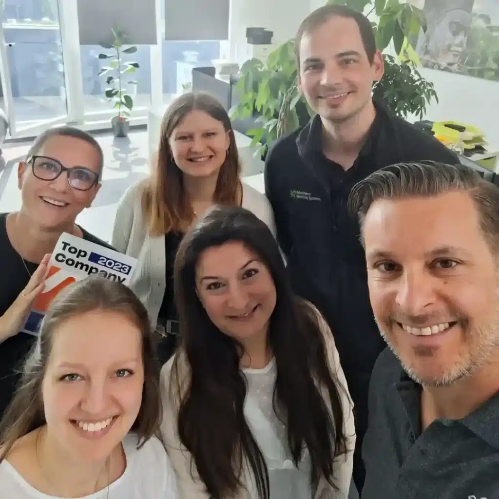 Selfie von lächelnden Mitarbeitern mit der höchsten Unternehmensauszeichnung