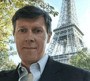 Porträt von Steven Keddie, Senior Director für GS1-Standards, der im Freien steht, im Hintergrund der Eiffelturm.