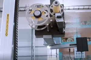 Automatisiertes Druck- und Anbringungssystem, das ein Barcode-Etikett auf eine palettierte Ladung verpackter Produkte aufbringt.